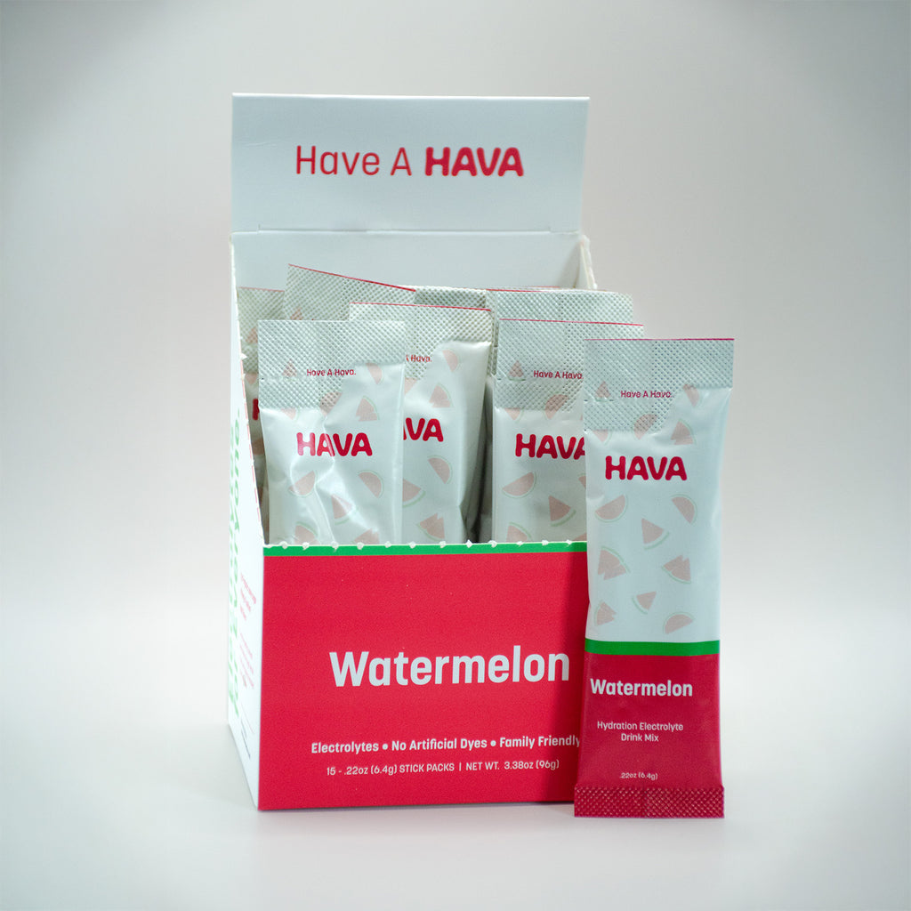 A HAVA Watermelon electrolyte powder box display with several individual packets arranged inside and one packet standing in front on a light gray studio background.