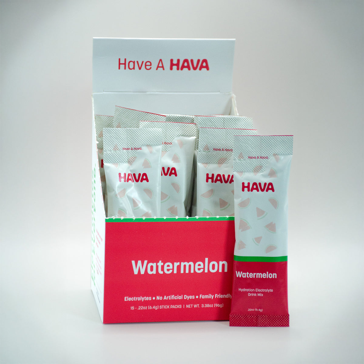 A HAVA Watermelon electrolyte powder box display with several individual packets arranged inside and one packet standing in front on a light gray studio background.